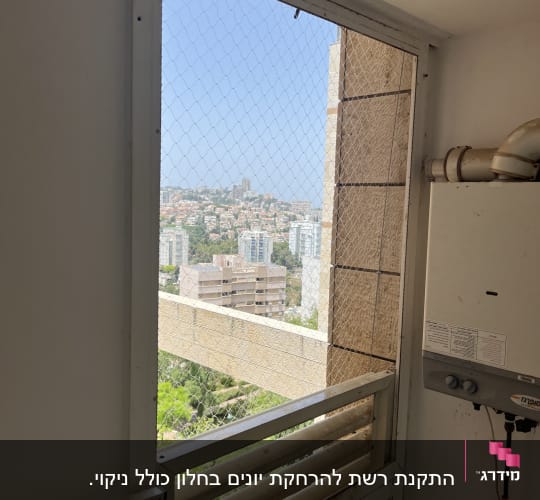 רשת מתכת מותקנת על חלון למניעת כניסת יונים